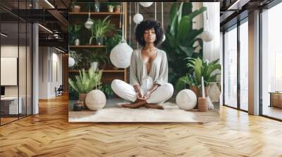 Young black woman sitting on the floor and meditating  in a beautiful room in her home Wall mural