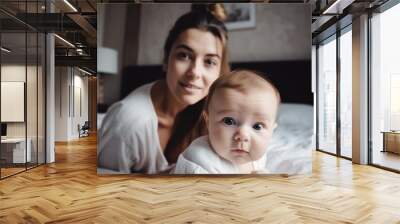 Young mother playing with her sweet three month old baby in the bedroom  Wall mural