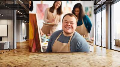 Young smiling man with Down syndrome on art workshop with a group of students, learning a new skill. Social integration concept. Wall mural