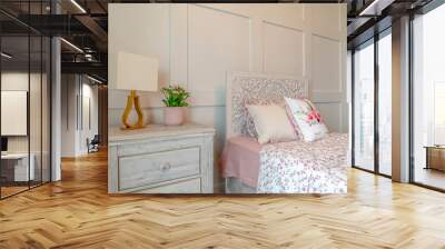 Bed with decorative head board against white panelled wall of feminine bedroom Wall mural