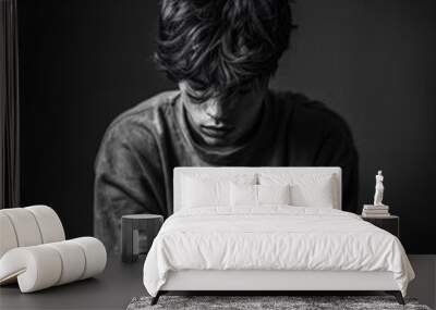 black and white phot of sad young man sitting alone Wall mural