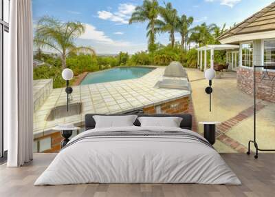 Day shot of a wonder California home with a large pool and counter space for a barbeque on a bright sunny day with puffy clouds Wall mural