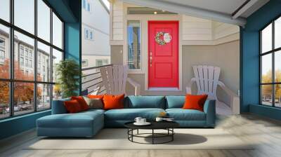 Entrance exterior of a house with two armchairs and red front door with wreath Wall mural