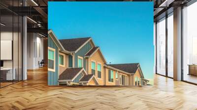 exterior of upper storey of townhomes with blue sky background on a sunny day Wall mural