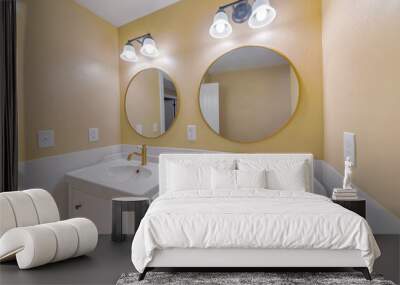 Part of a bathroom design with two sink and vintage round mirror on the wall with the golden frame. Wall mural