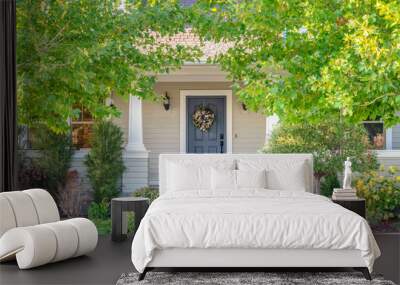 Front door of a home surrounded by leafy trees Wall mural