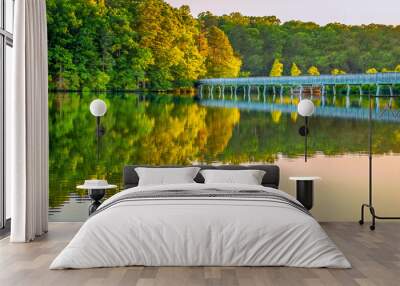 Reflection of bridge over lake at sunset Wall mural