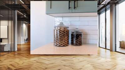 Square Jars of cookies on kitchen counter top against tile backsplash and white wall Wall mural