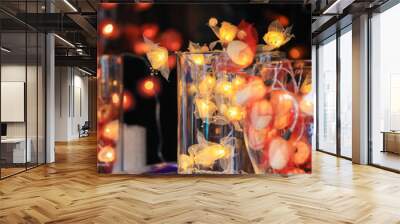 A table with a few vases of different sizes and shapes with Christmas lights  Wall mural