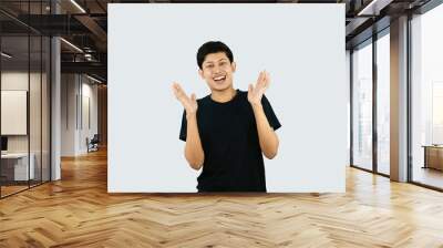 Young Asian Male boy with Black Tshirt points with finder gives expression and gestures of happy wow sad surprise Wall mural