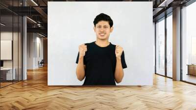 Young Asian Male boy with Black Tshirt points with finder gives expression and gestures of happy wow sad surprise Wall mural