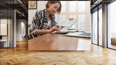 Businesswoman using calculator to calculate sale analysis Chart and investment profit Wall mural