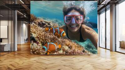 a woman wearing a mask swims next to a coral reef Wall mural