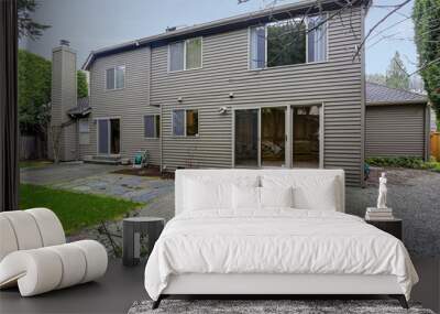 Private yard of a grey house with green grass. Wall mural