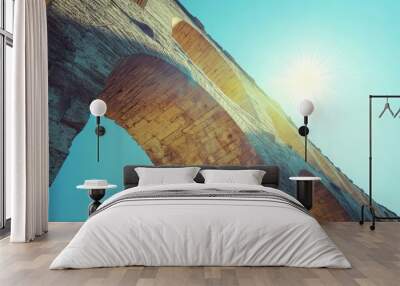 Aqueduct from underneath sun shining through arch and creating lens flare effect Wall mural