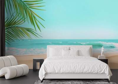 Beach scene with pale yellow sand azure sky gentle waves and a single palm frond Wall mural