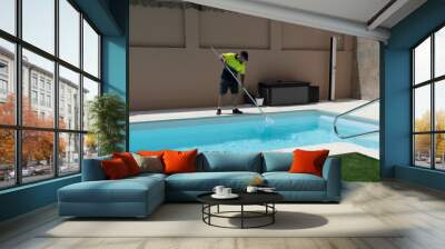 Operator cleaning a swimming pool with a butterfly trap Wall mural