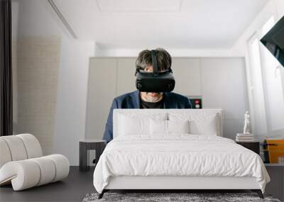 Stylish adult male pretending to eat in a modern kitchen experiencing virtual reality on the empty plate. Virtual reality glasses. Virtual food, Virtual lunch Wall mural