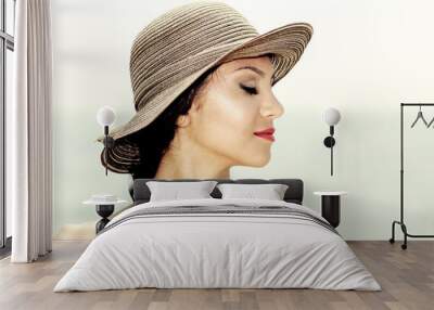 Attractive woman with a sun hat on a tropical beach, eyes closed Wall mural