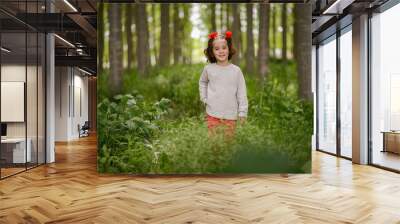 Cute little girl having fun in a poplar forest Wall mural