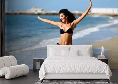 Young arabic woman with beautiful body in swimwear smiling on a tropical beach. Wall mural