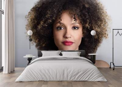 Young black woman with afro hairstyle on white background Wall mural