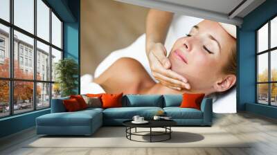 Young woman receiving a head massage in a spa center. Wall mural