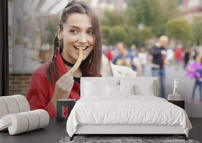 Cheerful brunette girl in the town fair, eating traditional spanish snack named 