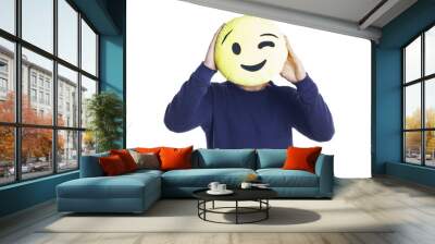 Man standing over a white background, holding a winking emoji plush. Isolated. Wall mural