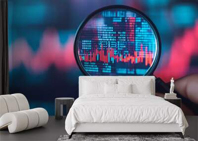 A close-up view of a magnifying glass over digital stock market data, showcasing trends and statistics in vibrant colors. Wall mural