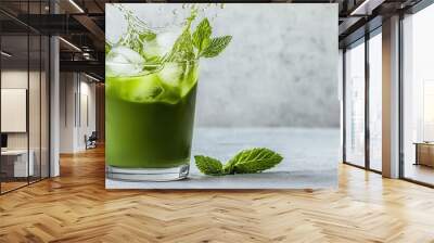 Iced matcha tea splashing out of a glass with ice cubes and mint leaves in mid-motion   matcha tea splash, refreshing energy Wall mural