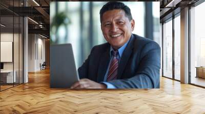 Happy mature middle aged professional business mexican american man bank worker or hr manager, corporate executive looking away at work working on laptop computer in office thinking of business techno Wall mural