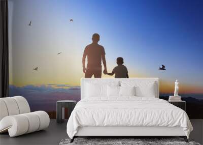 Father and son holding hand in hand at the sunrise time. Wall mural