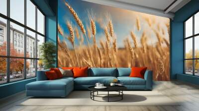 Golden wheat field under a vibrant sky at sunset with fluffy clouds enhancing the picturesque landscape Wall mural