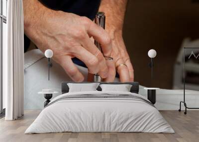 Hands of a Chiropractor Using an Integrator to Adjust the Spine of a Patient Wall mural