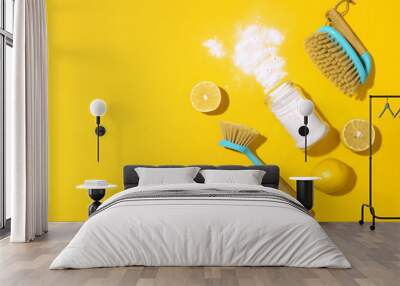 Baking soda, lemon, mustard powder and bamboo brushes against household chemicals products over yellow background. Top view. Copy space. Flat lay. Effective and safe house cleaning Wall mural