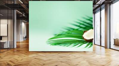 Coconut over tropical green palm leaves on turquoise background. Copy space. Pop art design, creative summer concept. Raw vegan food. Banner Wall mural