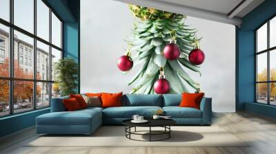 Creative Christmas tree made of pineapple and red bauble on grey concrete background, copy space. Greeting card, decoration for new year party. Holiday concept. Square crop Wall mural