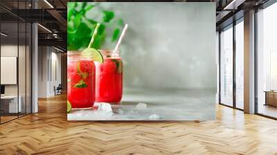 Fresh red watermelon slice and smoothie in glass jar with straw, ice, mint, lime on light background, copy space Wall mural