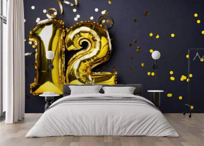 Gold foil balloon number, digit twelve. Birthday greeting card, inscription 12. Anniversary celebration event. Banner. Stylish golden numeral, light bokeh, glitter, black background. Numerical digit Wall mural