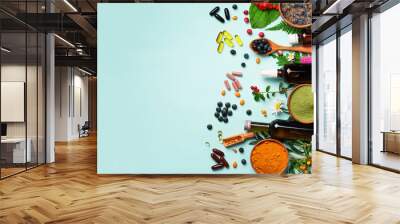 Holistic medicine approach. Healthy food eating, dietary supplements, healing herbs and flowers. Turmeric, dried lavender, spirulina powder in wooden bowls, fresh berries, omega acid capsules Wall mural