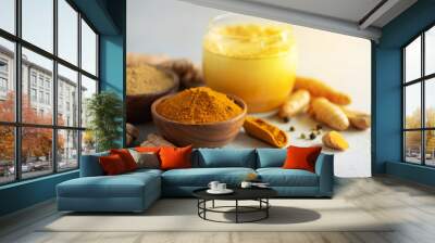 Hot healthy drink. Turmeric latte, golden milk with turmeric root, ginger powder, black pepper over grey background. Copy space. Spices for ayurvedic treatment. Alternative medicine concept. Wall mural