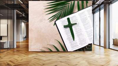 Palm Sunday concept. Palm cross on open Holy Bible and palm leaves. Reminder of Jesus sacrifice and Christ resurrection. Easter passover. Eucharist concept. Christianity symbol and faith Wall mural