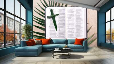 Palm Sunday concept. Palm cross on open Holy Bible and palm leaves. Reminder of Jesus sacrifice and Christ resurrection. Easter passover. Eucharist concept. Christianity symbol and faith Wall mural