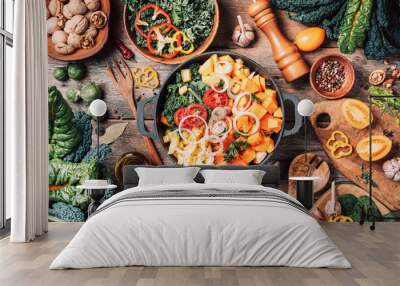 Pot with sliced colorful vegetables and cooking utensils on rustic wooden background. Top view. Organic vegetarian ingredients and kitchen tools. Healthy, clean food and eating concept. Zero waste Wall mural