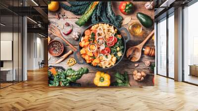 Pot with sliced colorful vegetables and cooking utensils on rustic wooden background. Top view. Organic vegetarian ingredients and kitchen tools. Healthy, clean food and eating concept. Zero waste Wall mural