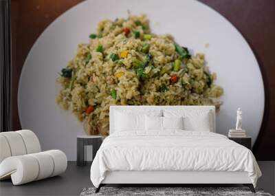 Green curry fried rice with long beans, basil leaves, corn, and meat served in a white plate. Wall mural