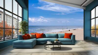 Surf Fishing two rods in the sand on coastline with white beach chair for lounging and relaxing on summer holiday Wall mural