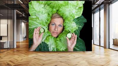 Cute woman with salad leaves arranged around her head, playing w Wall mural