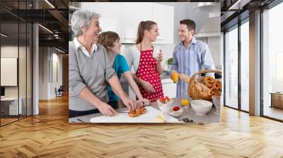 Lachende glückliche Familie beim Kochen mit Oma Wall mural